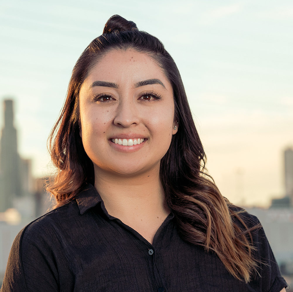 A headshot of Marissa Ayala. She is wearing a black shirt and has her hair in a bun and is smiling.